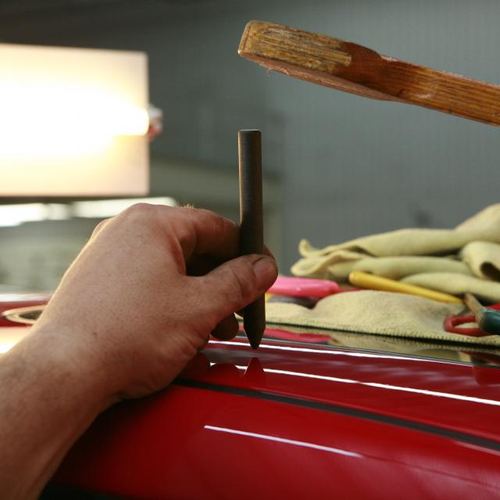 Trabajo de acabado sobre la carrocería de un coche rojo
